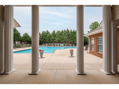 a view of a swimming pool from a patio with columns